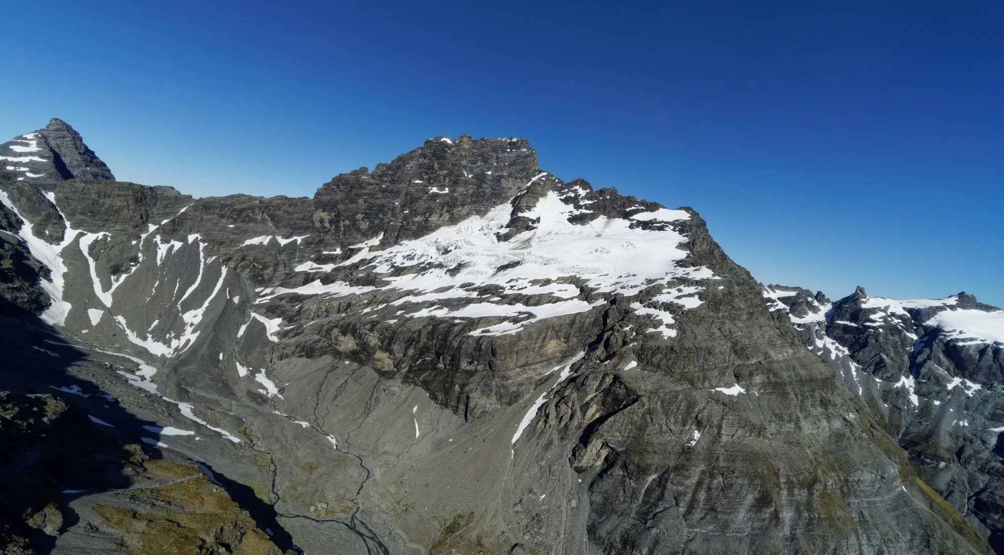 Snow-streaked alpine summit and its glacier photographed from a helicopter in Mount Aspiring National Park