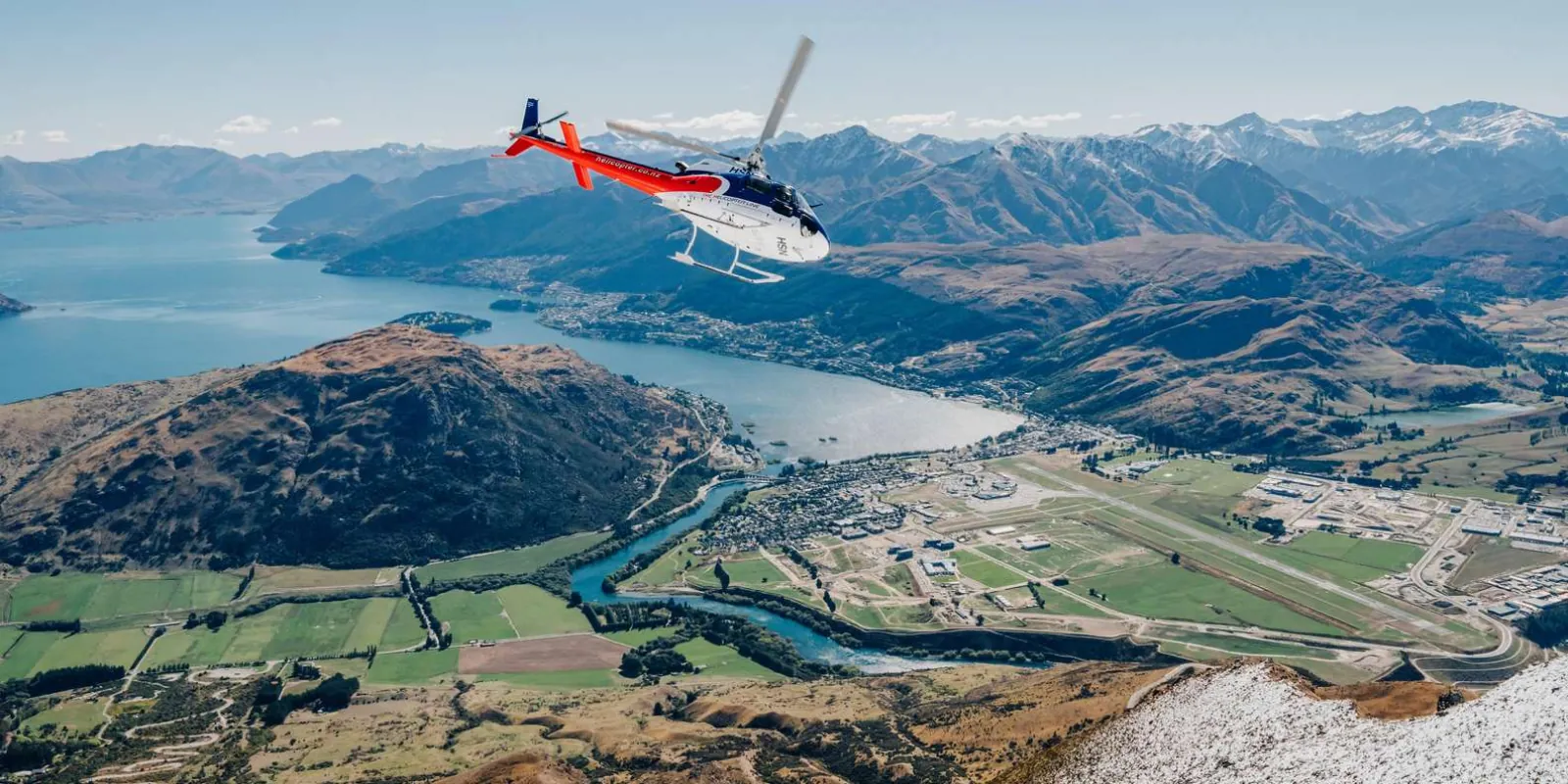 Helicopter banking over Lake Wakatipu with Frankton and the Whakatipu Basin spread out below