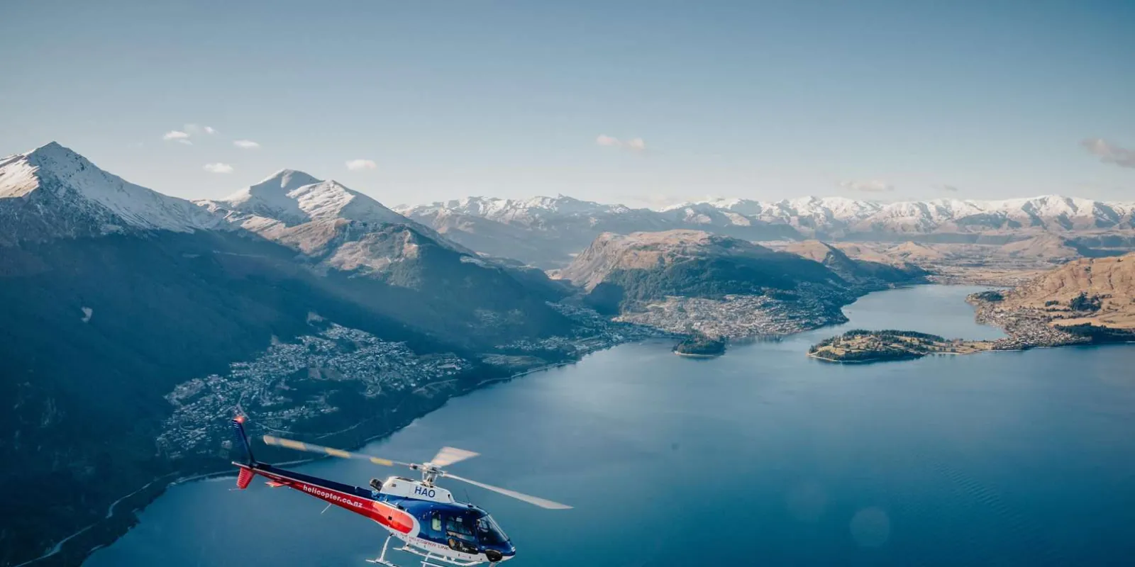 Wide aerial of Lake Wakatipu with the helicopter a speck against the water