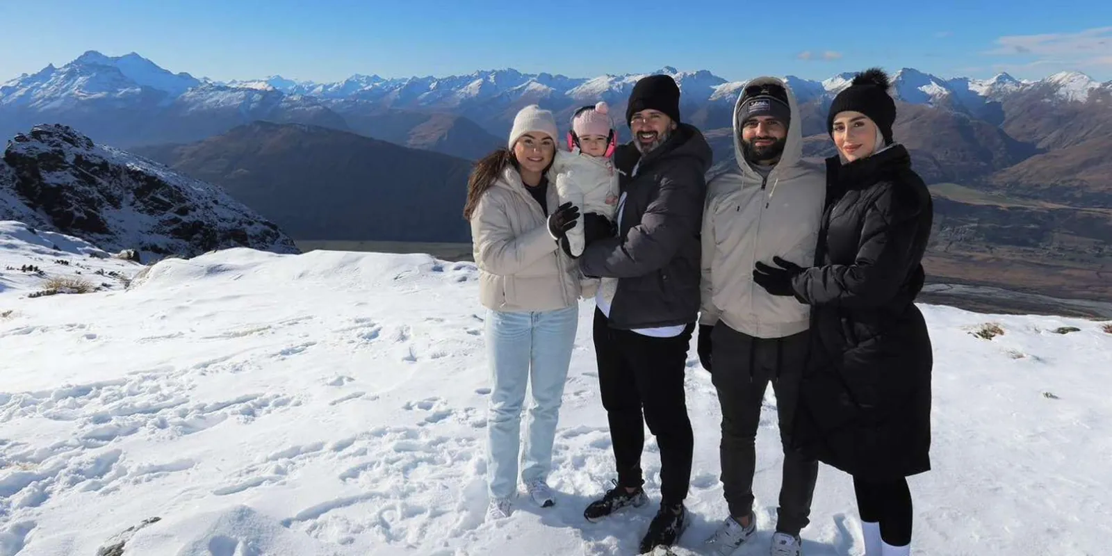 Family group standing together in deep snow beside the landing site